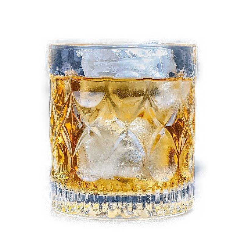 Verre à whisky Gouttes Taillées rempli de whisky avec un gros glaçon, vue de face